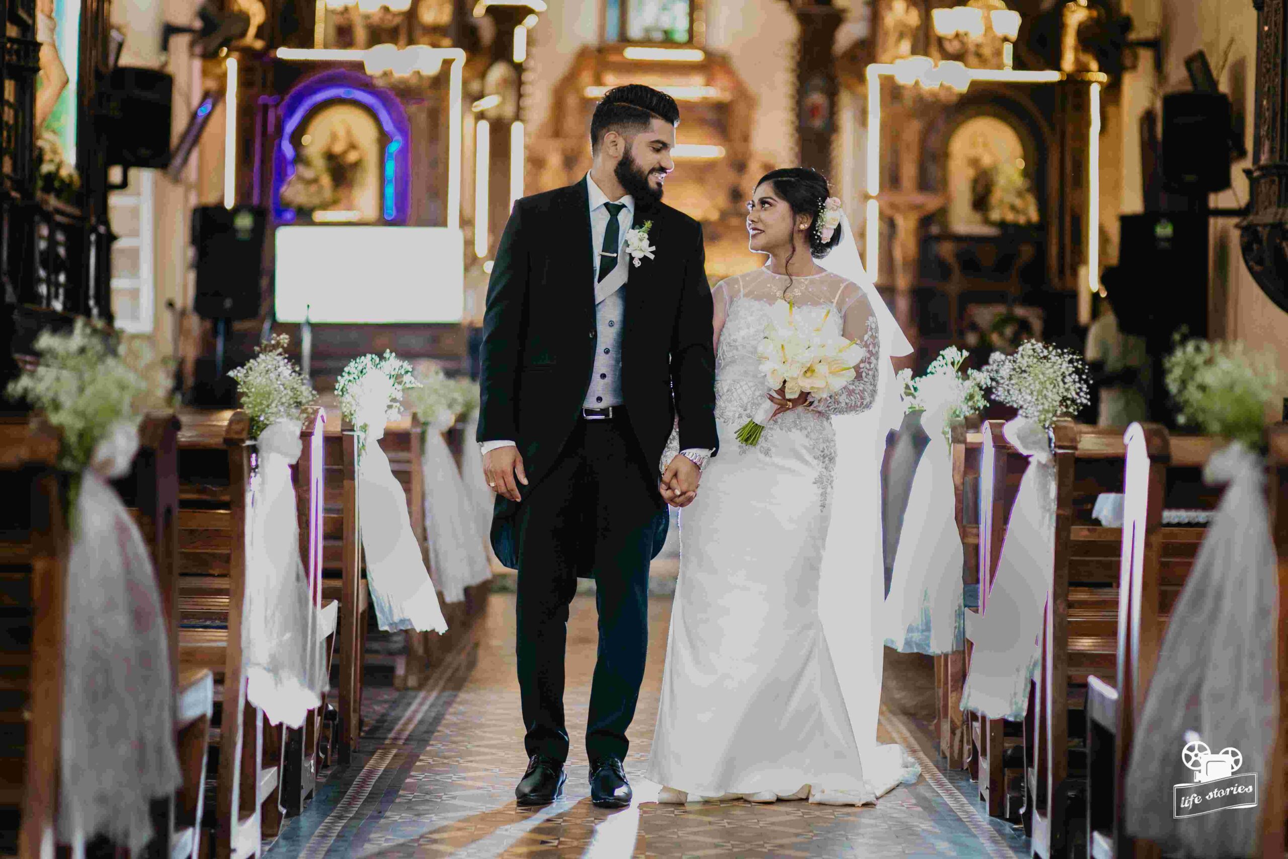 The perfect church wedding where the groom and bride hand in hand look at each other admiringly.