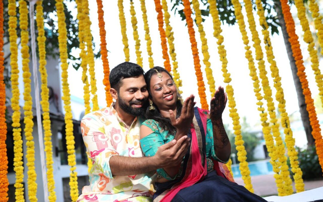 A pre wedding ritual setup with the bride and groom admiring the bride's mehndi.