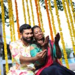 A pre wedding ritual setup with the bride and groom admiring the bride's mehndi.