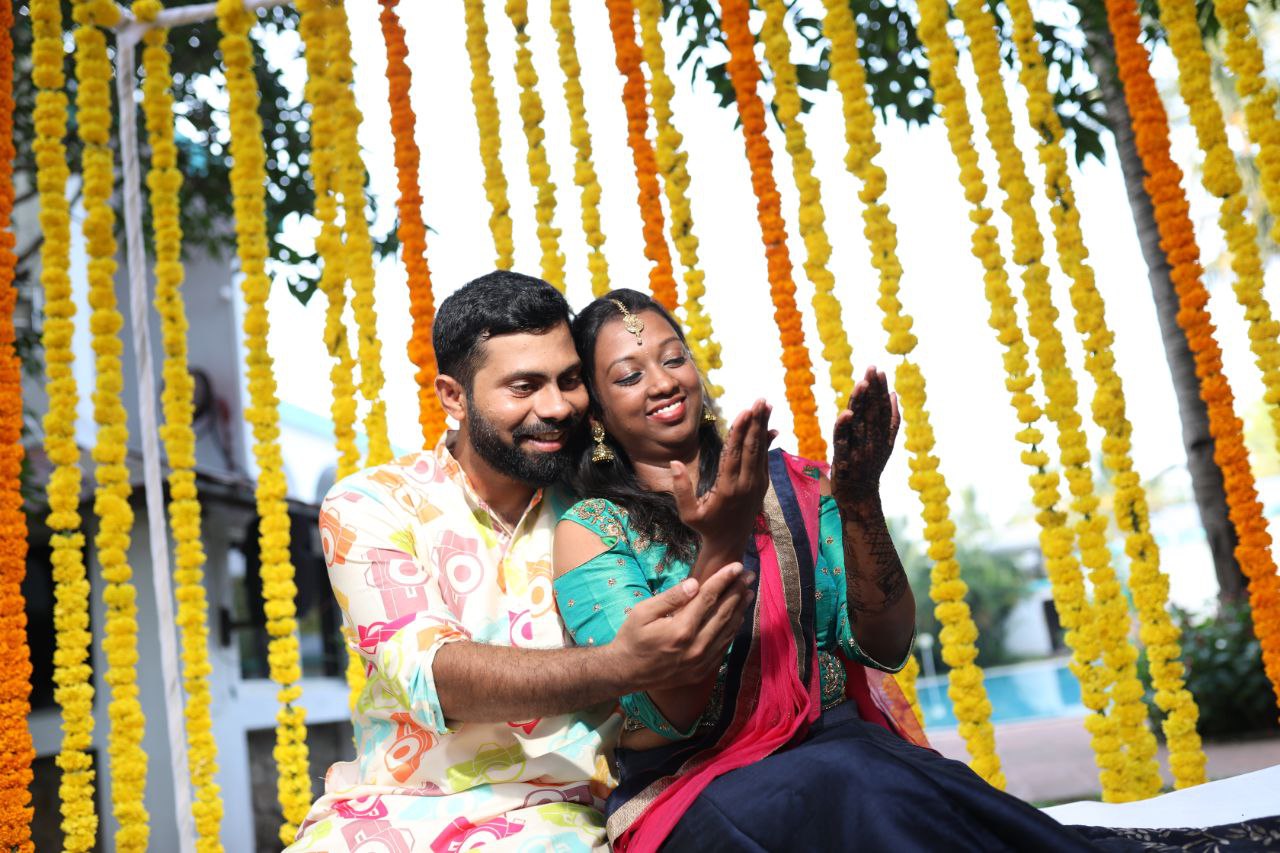 A pre wedding ritual setup with the bride and groom admiring the bride's mehndi.