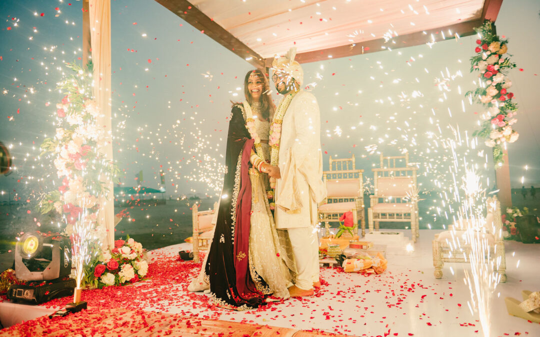 The newlyweds pose as the sparkles shine on either side of the stage.