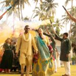 People with colorful smoke stick welcoming the bride and the groom.