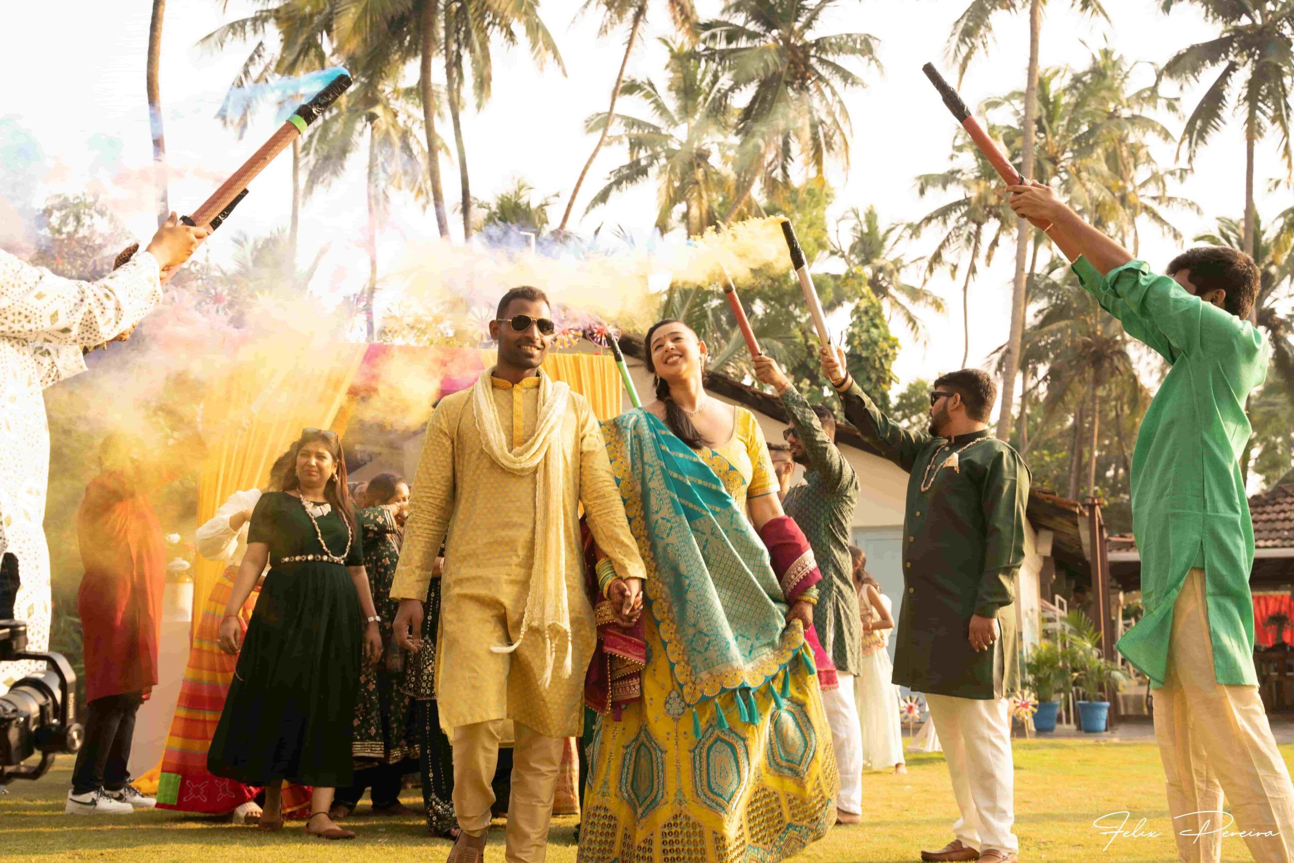 People with colorful smoke stick welcoming the bride and the groom.