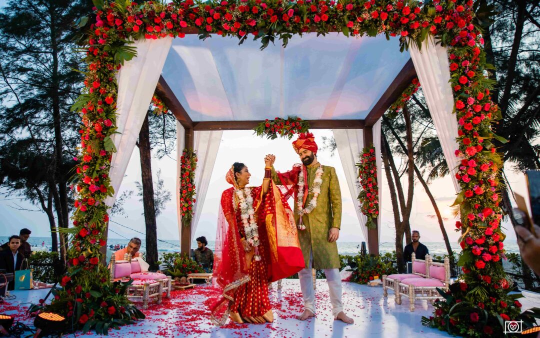 The groom lifting the bride's hand as they admire each other.