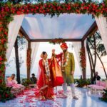 The groom lifting the bride's hand as they admire each other.